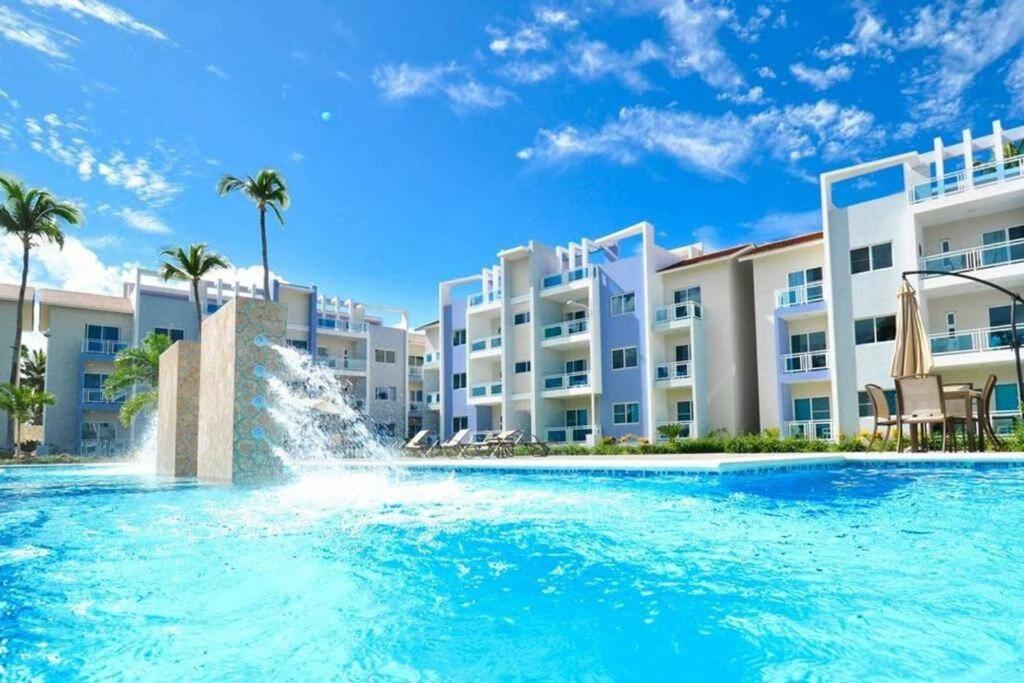 einem Pool mit einem Brunnen vor einem Gebäude in der Unterkunft Espacio Tropical a pasos de la playa caribeña in Punta Cana