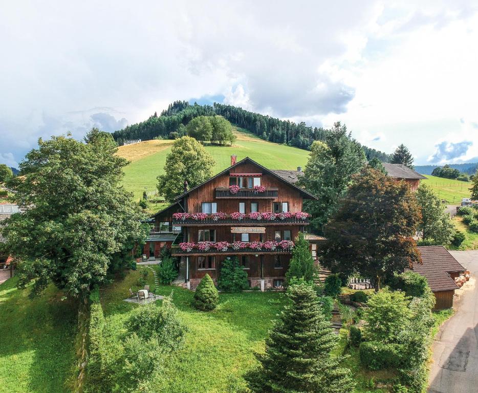 uma casa no lado de uma colina com árvores em Oberdeisenhof Land- und Wanderhotel Garni em Baiersbronn