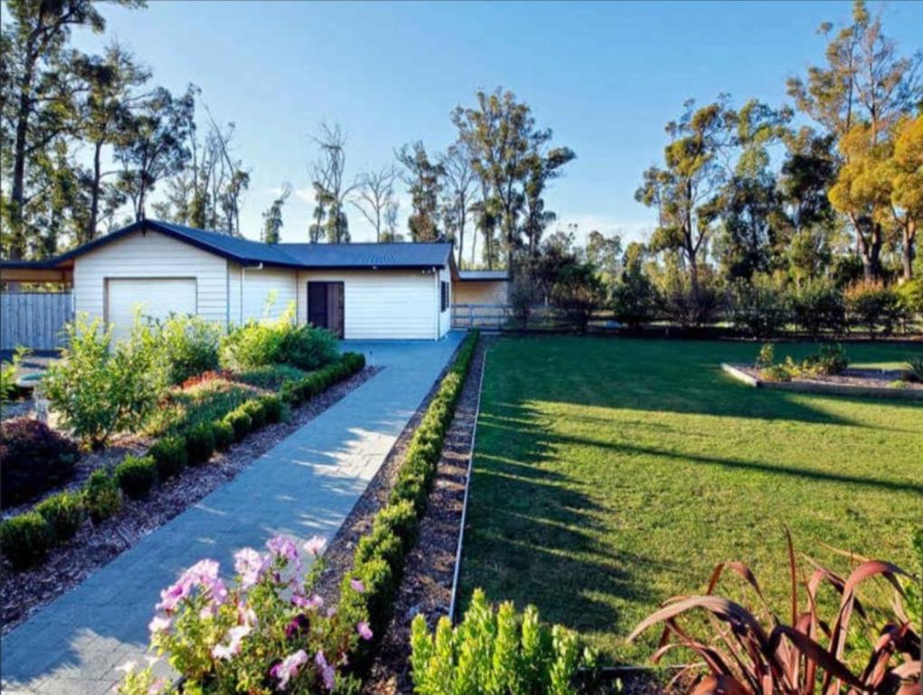 a house with a garden in front of it at The Cosy Cottage in Port Sorell