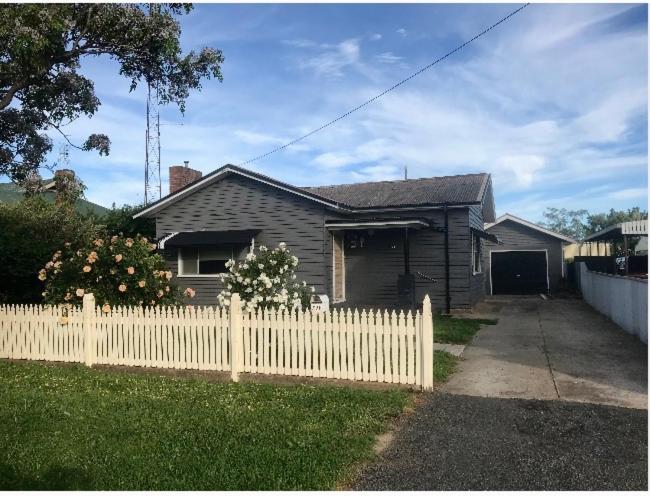 una casa con una recinzione bianca davanti di Parker st a Cootamundra