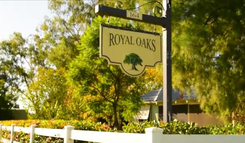 a street sign for royal oaks in front of a house at Peaceful cabin in a rural setting 2km from CBD in Tamworth