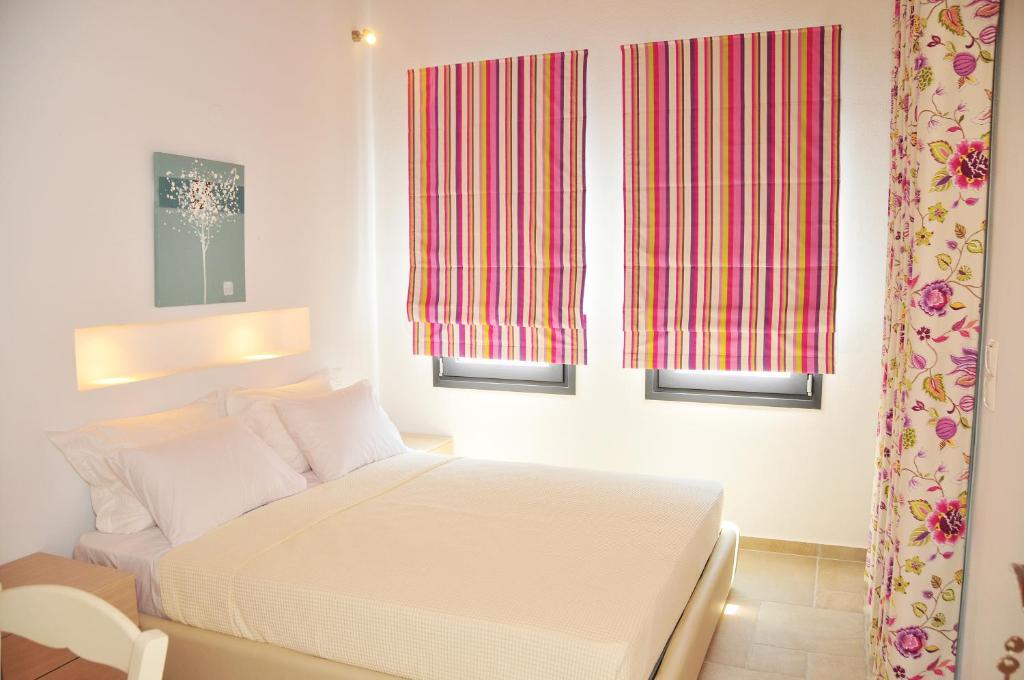 sypialnia z białym łóżkiem i 2 oknami w obiekcie Kleopatra Villas - Seaside Suites w mieście Kolios