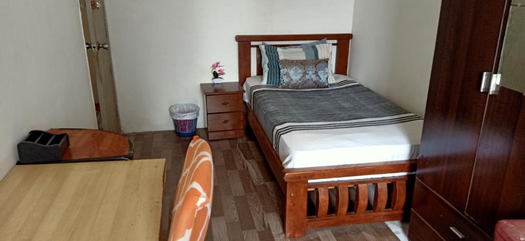 a small bedroom with a bed and a dresser at Low Budget SuperSingleBed Bedroom in Kuala Lumpur