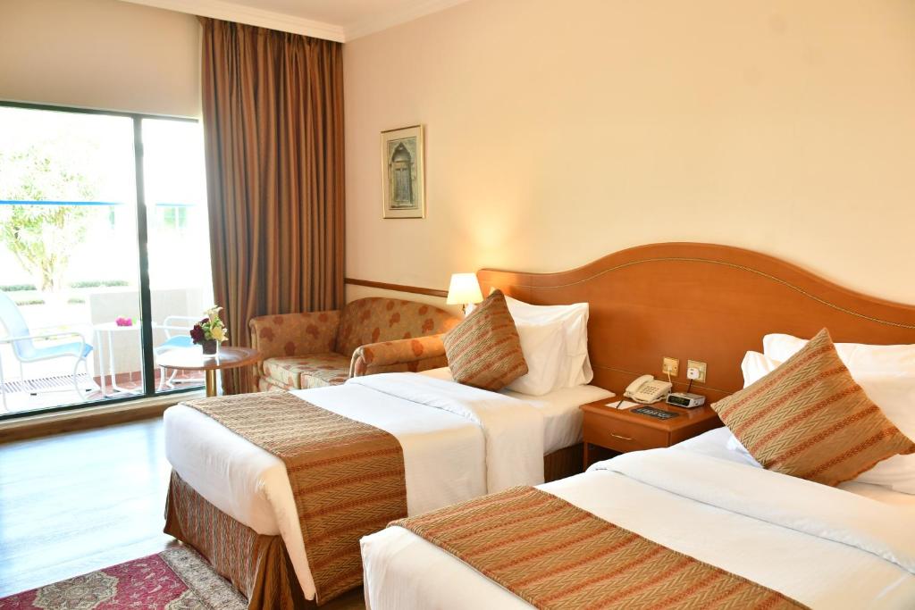 Postel nebo postele na pokoji v ubytování Golden Tulip Nizwa Hotel