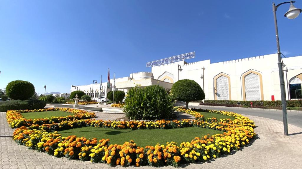 uma exposição de flores em frente a um edifício em Golden Tulip Nizwa Hotel em Nizwa