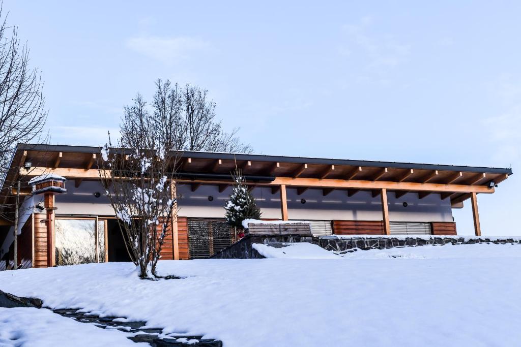 a house with a snow covered yard in front of it at Crab's Creek Zagreb in Rakov Potok