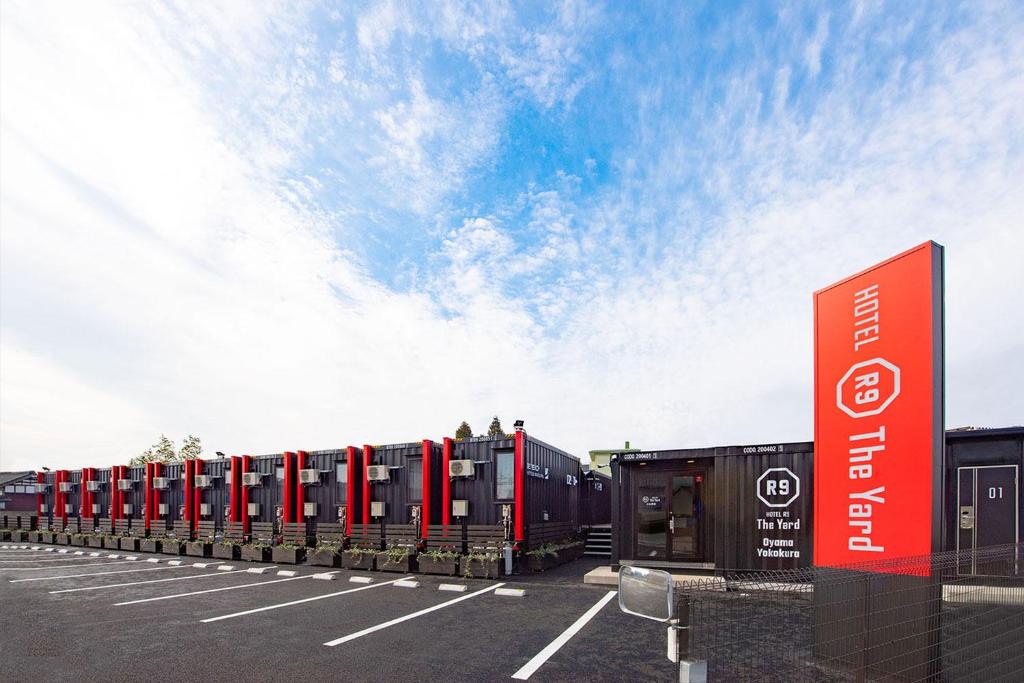 una fila de autos estacionados en un estacionamiento en HOTEL R9 The Yard Oyamayokokura, en Oyama