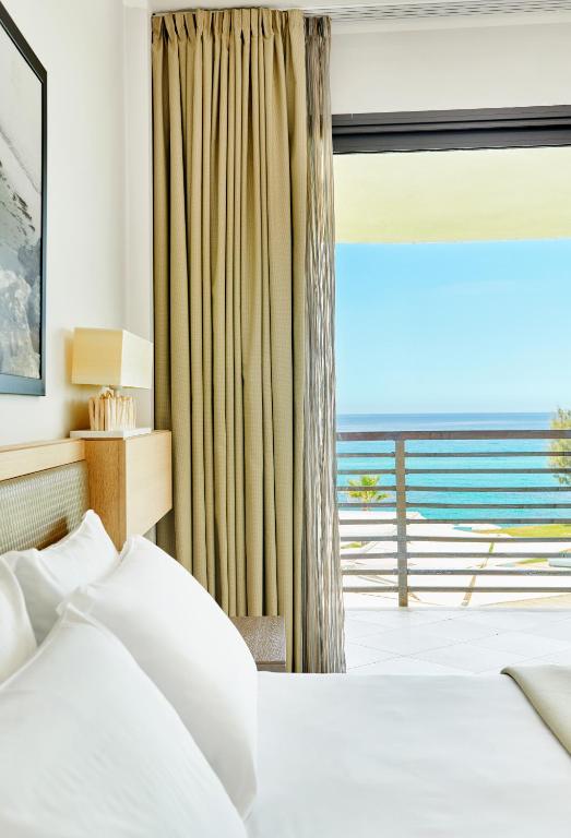 a bedroom with a bed and a large window at Capovaticano Resort Thalasso Spa in Capo Vaticano
