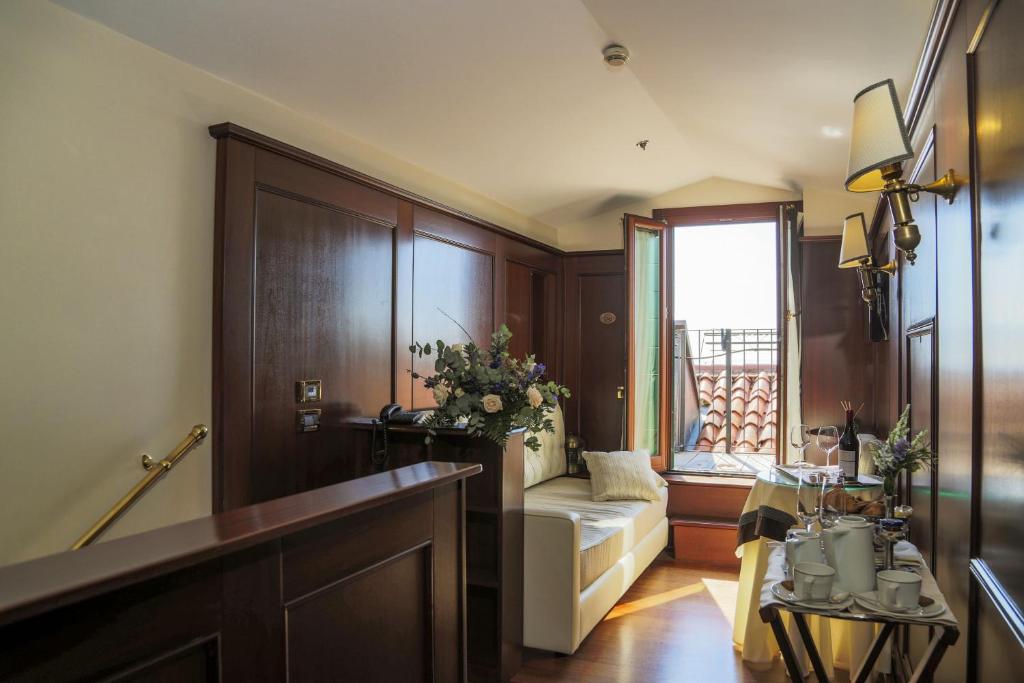 a living room with a couch and a window at Hotel Bucintoro in Venice