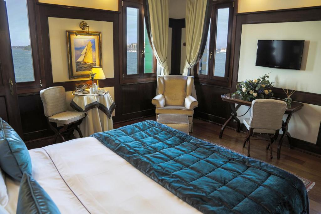 a bedroom with a bed and a table and chairs at Hotel Bucintoro in Venice