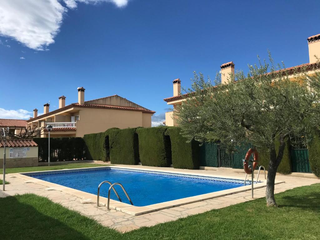 a swimming pool in front of a house at MEDDAYS CHALET BELLAVISTA in Miami Platja