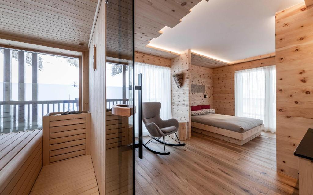 a bedroom with a bed and a desk and a chair at La Majun Fornellahof in Antermoia