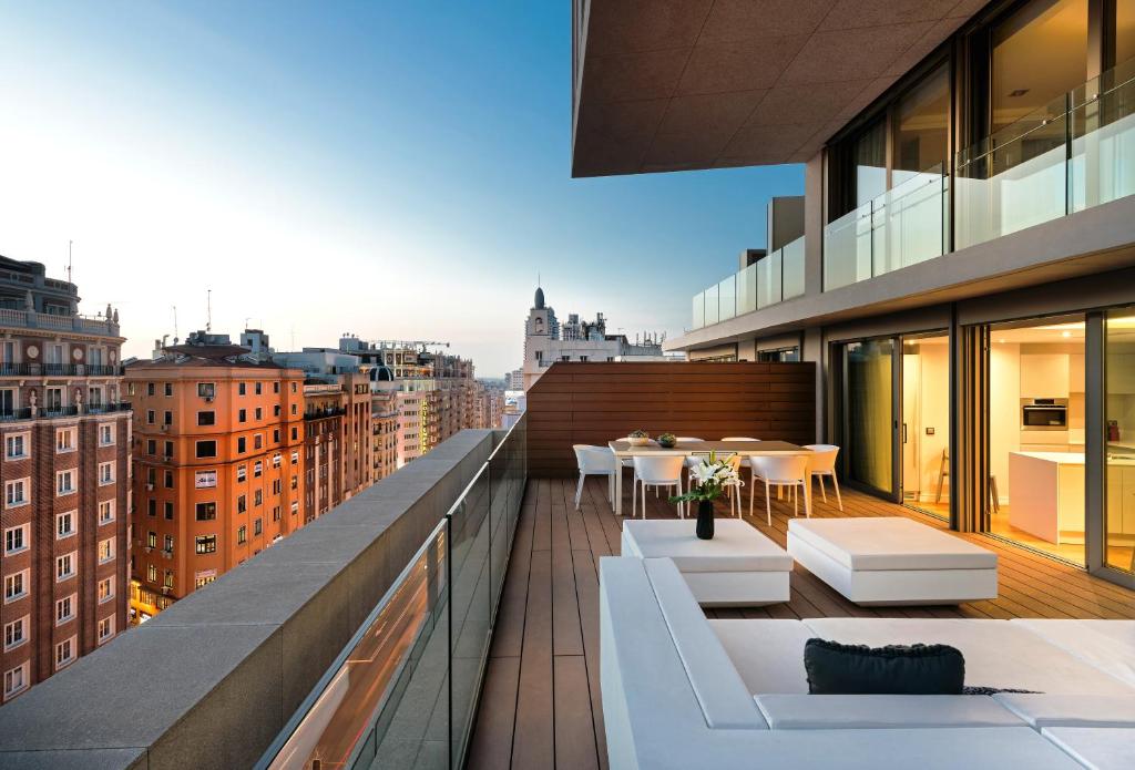 einen Balkon mit Tischen und Stühlen auf einem Gebäude in der Unterkunft Gran View Apartments in Madrid