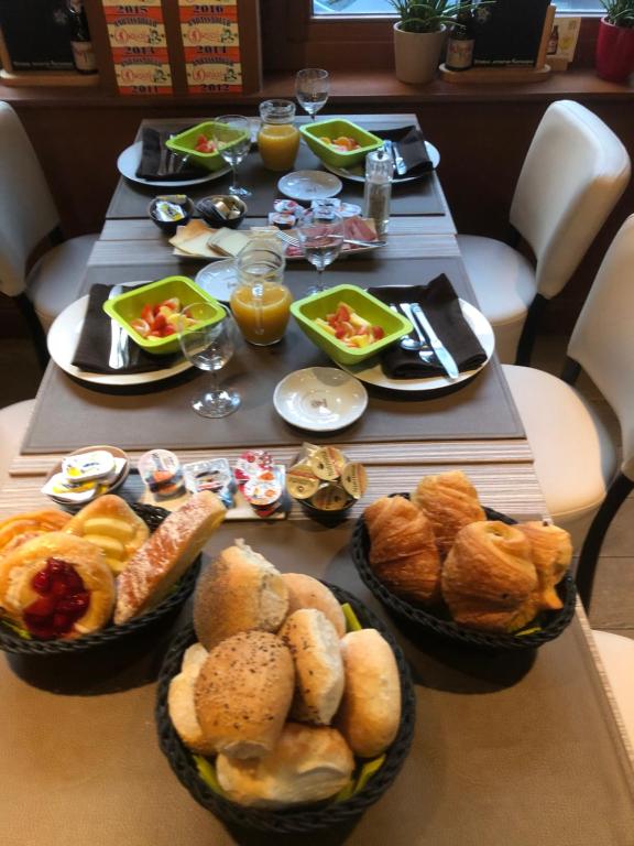 a table topped with baskets of bread and pastries at Hotel Duivels Paterke Harelbeeksestraat 29, 8500 Kortrijk in Kortrijk
