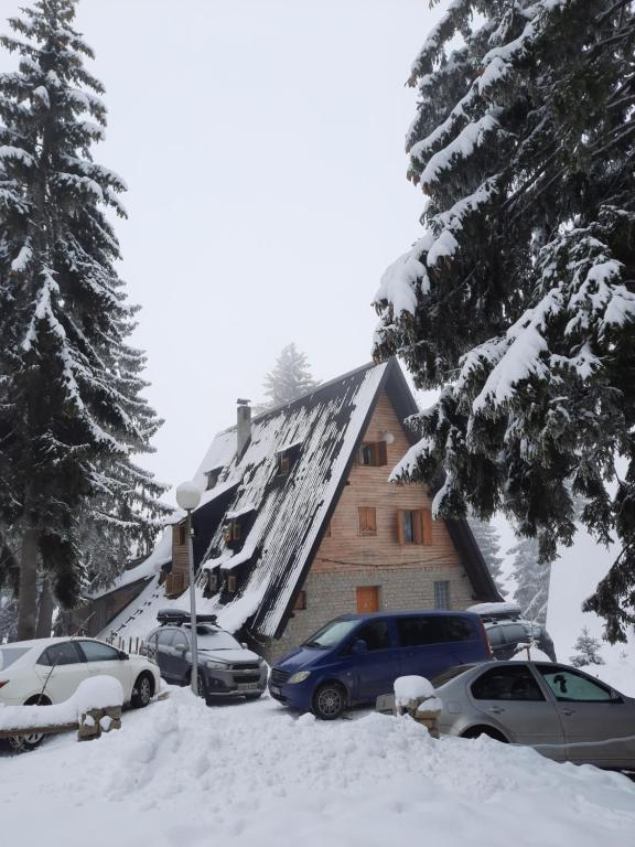 a house with cars parked in the snow at Apartments A Vlasic in Vlasic