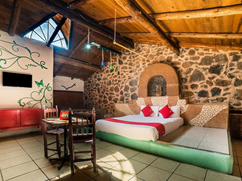 een slaapkamer met een bed in een stenen muur bij Cabañas Tres Joyas in San Miguel Regla