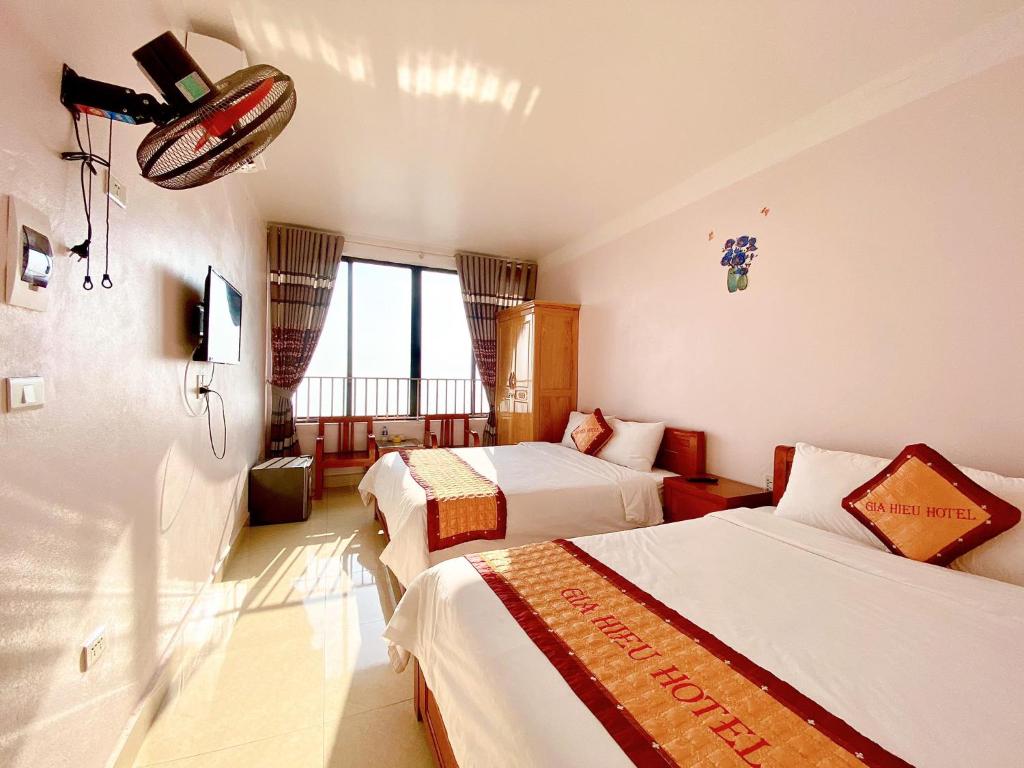 a hotel room with two beds and a window at Gia Hiếu Hotel in Sơn Ðình