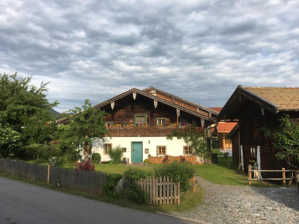 uma casa com uma porta azul e uma cerca em Webergütl - Chiemgau Karte em Inzell
