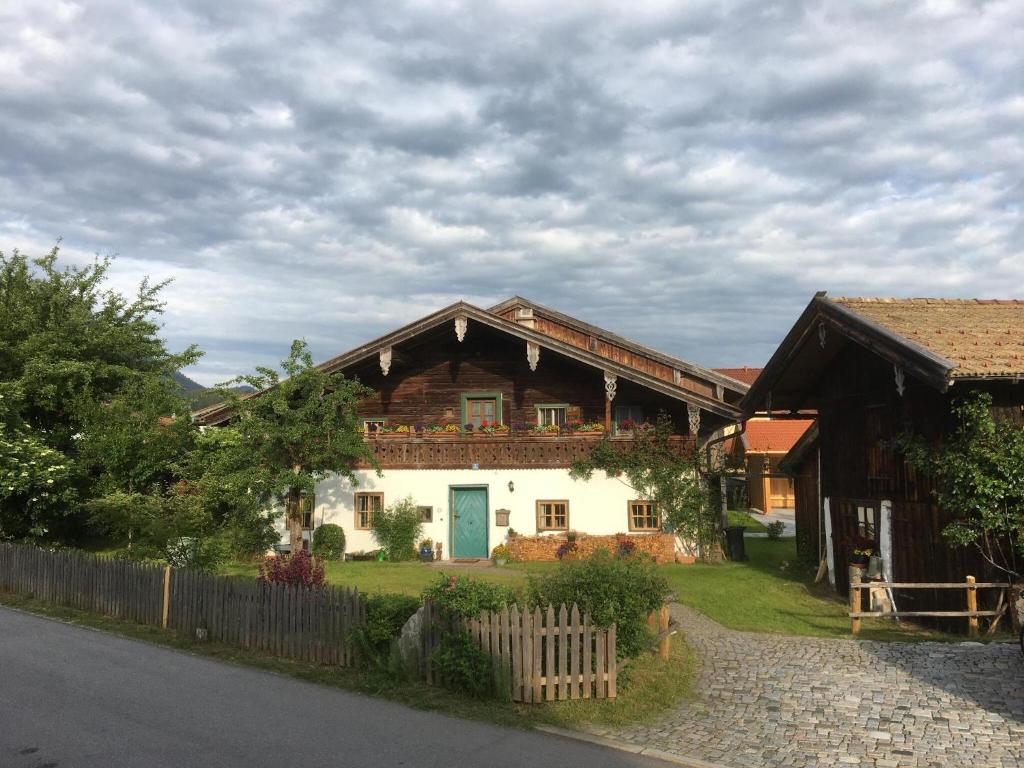 a house with a blue door and a fence at Webergütl - Chiemgau Karte in Inzell