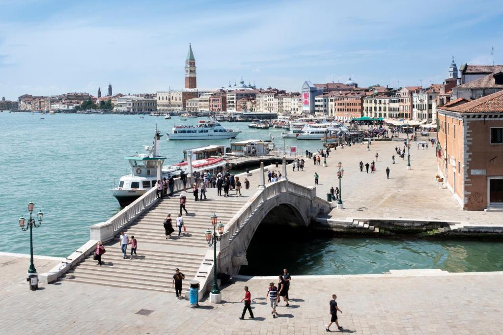 a group of people walking on a pier next to the water at Hotel Bucintoro in Venice
