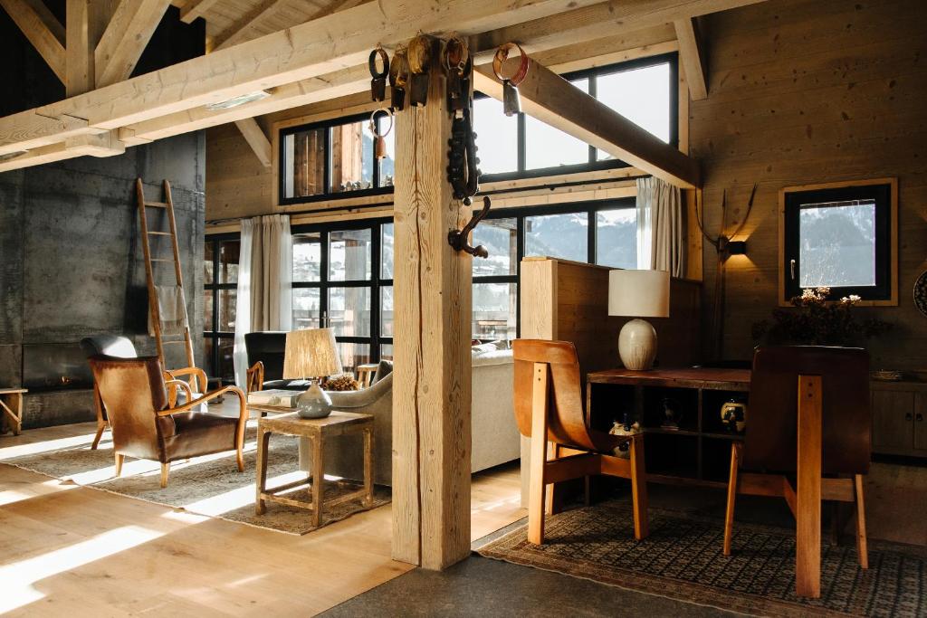 a room with a desk and chairs and windows at L'Alpaga, a Beaumier hotel in Megève