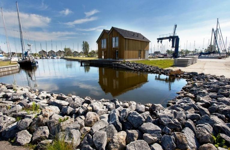 a small house on the water near a rocky shore at Roggebroek 13 in Stavoren