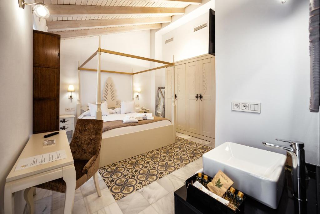 y baño con cama, lavabo y bañera. en Hotel boutique Palacio de la Veracruz en Alcalá la Real