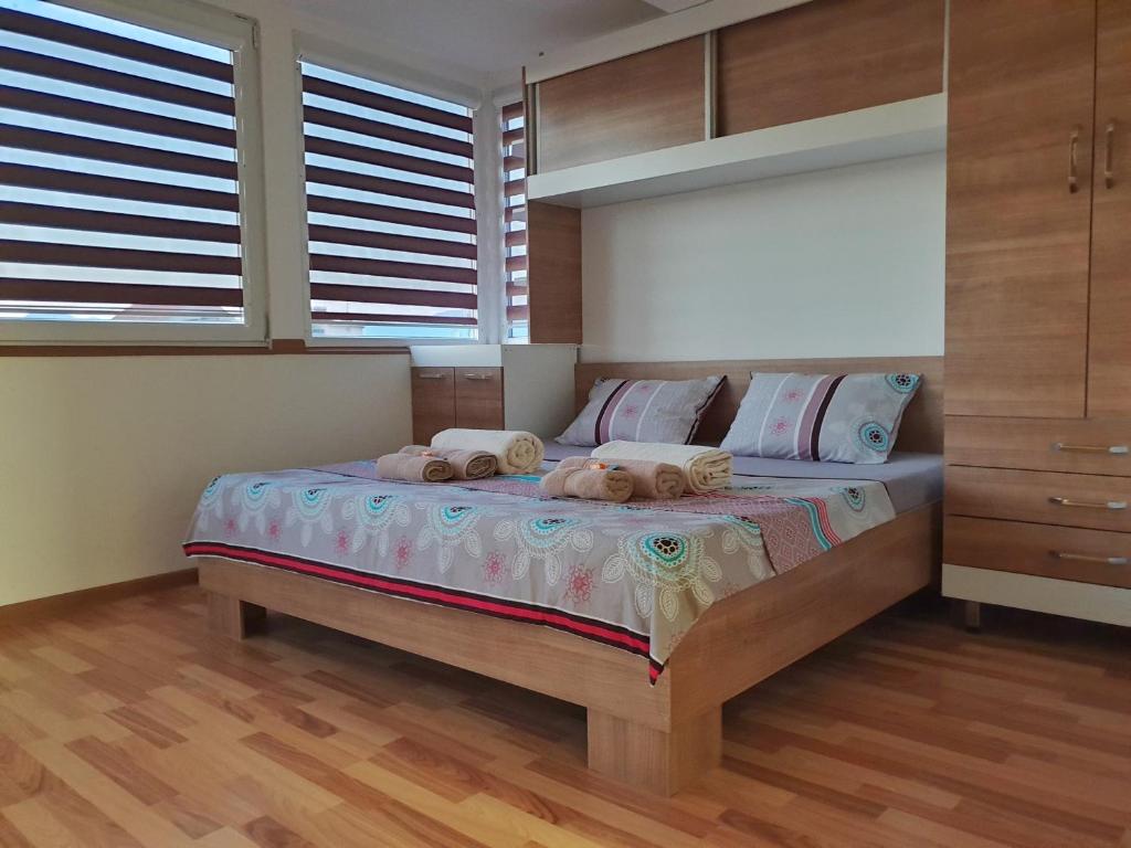 a bedroom with a bed with two stuffed animals on it at Sky Apartments in Strumica