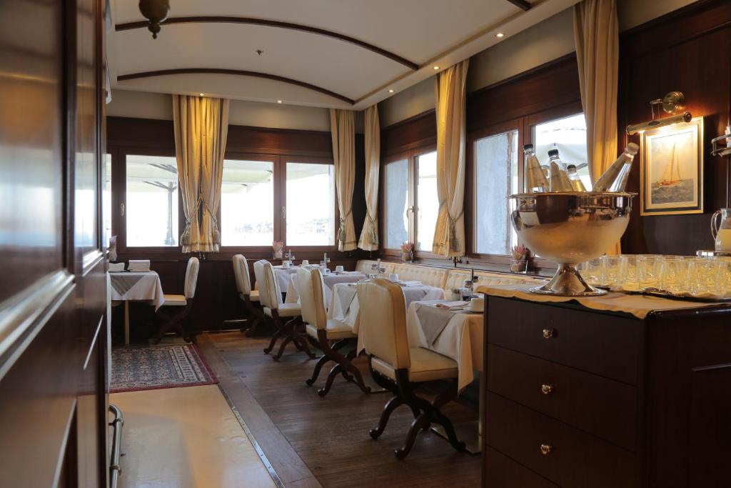 a dining room with a long table with white chairs at Hotel Bucintoro in Venice