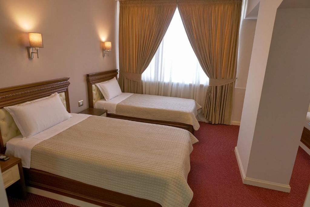 Postel nebo postele na pokoji v ubytování Rozafa Hotel
