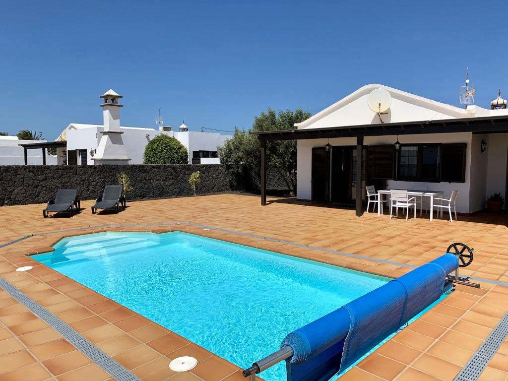 a swimming pool in front of a house at Casas Tomare I in San Bartolomé