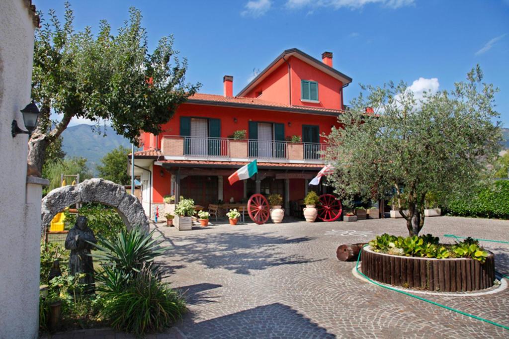 een rood huis met een binnenplaats ervoor bij Azienda Agrituristica Pericle in Montella