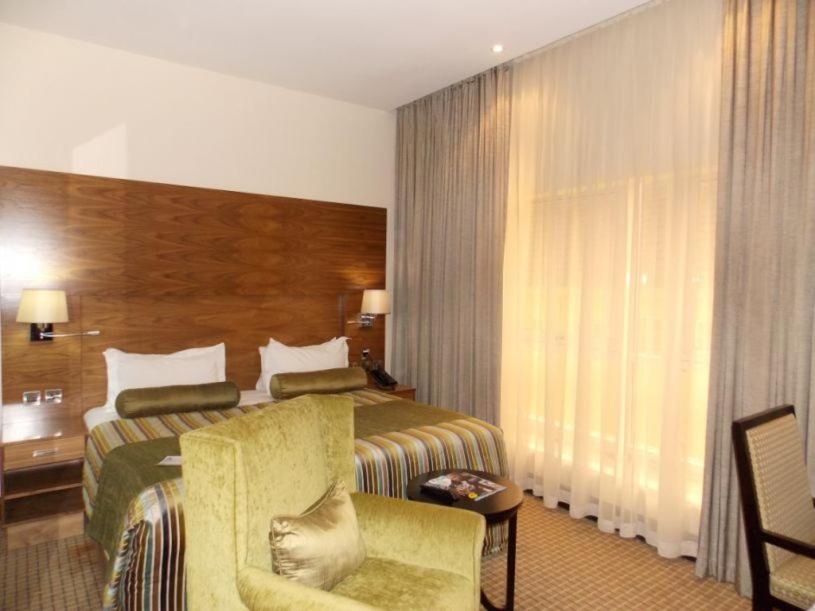 a hotel room with a bed and a chair at BON Hotel Grand Towers in Abuja