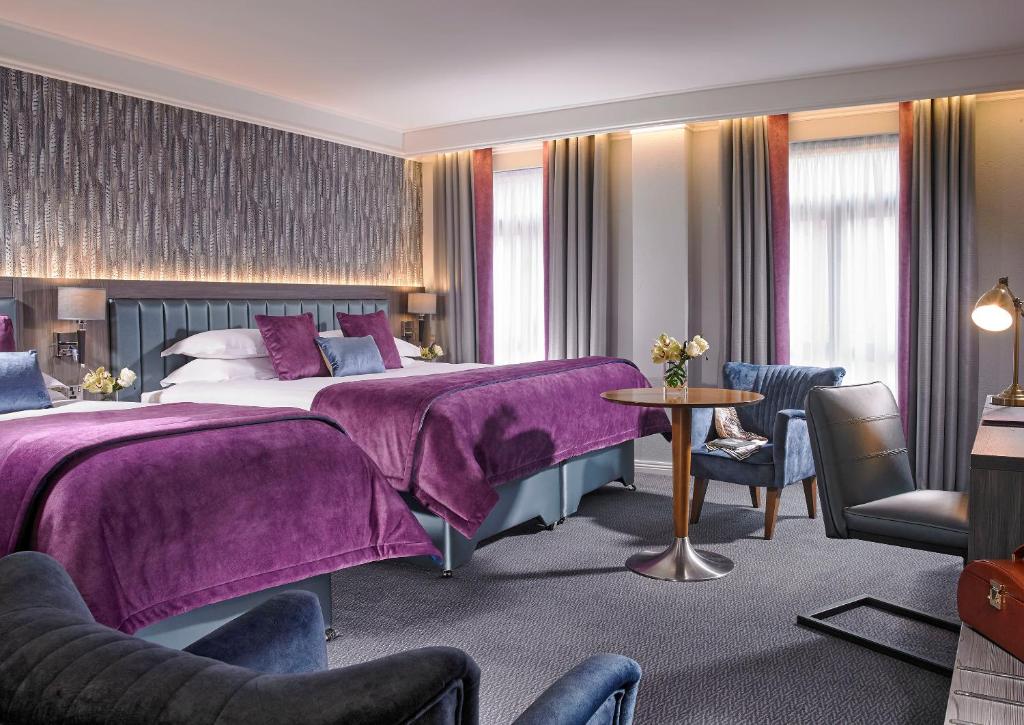 um quarto de hotel com uma cama com lençóis roxos em Kilkenny Ormonde Hotel em Kilkenny