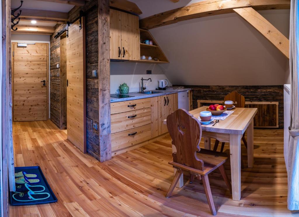 a kitchen with wooden floors and a wooden table and chair at Tourist Farm Šenkova Domačija in Zgornje Jezersko