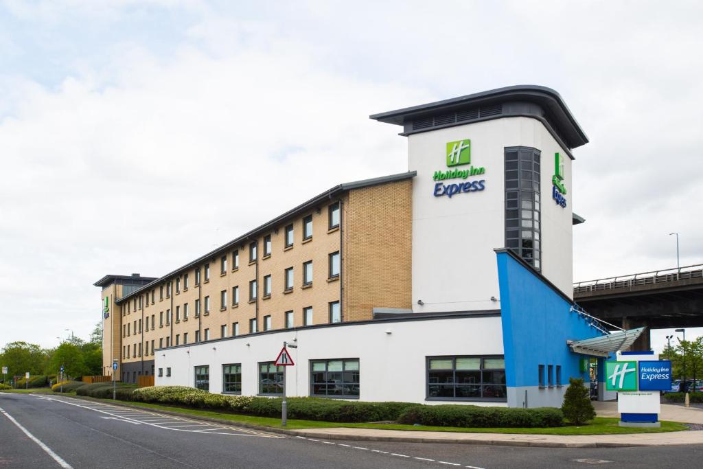 un edificio con un cartello sul lato di una strada di Holiday Inn Express - Glasgow Airport, an IHG Hotel a Paisley