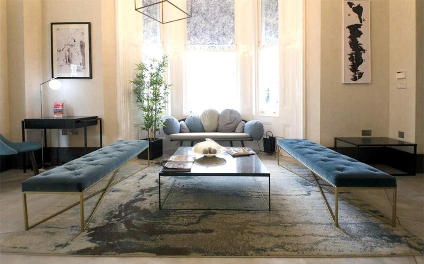 a living room with two couches and a table at K Hotel Kensington in London