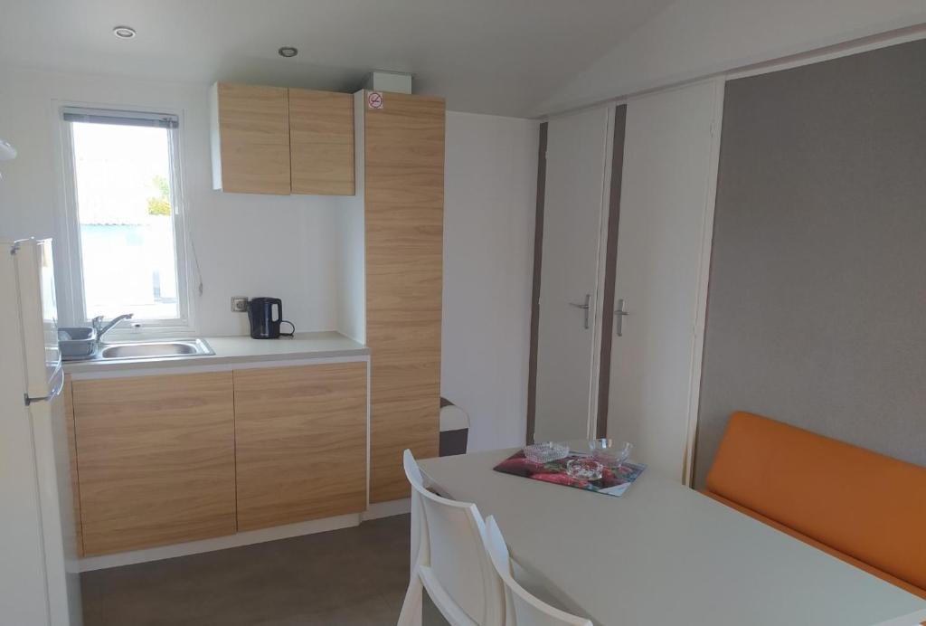 a kitchen with a bed and a sink in a room at Mobile Homes by KelAir at Camping Sylvamar in Labenne