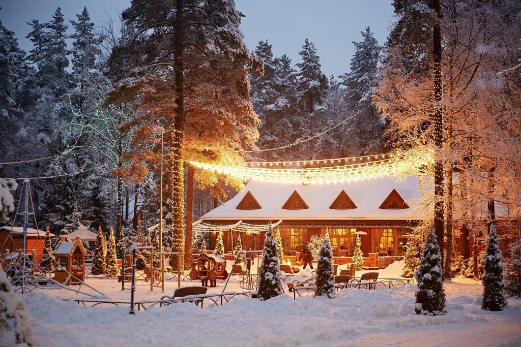 una casa cubierta de luces de Navidad en la nieve en Tsarstvo Korolevstvo, en Roshchino