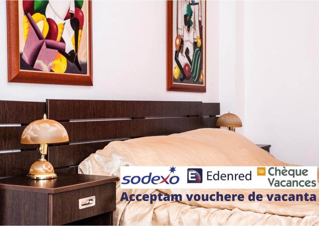 a bedroom with a bed and paintings on the wall at Vila Diamant in Neptun