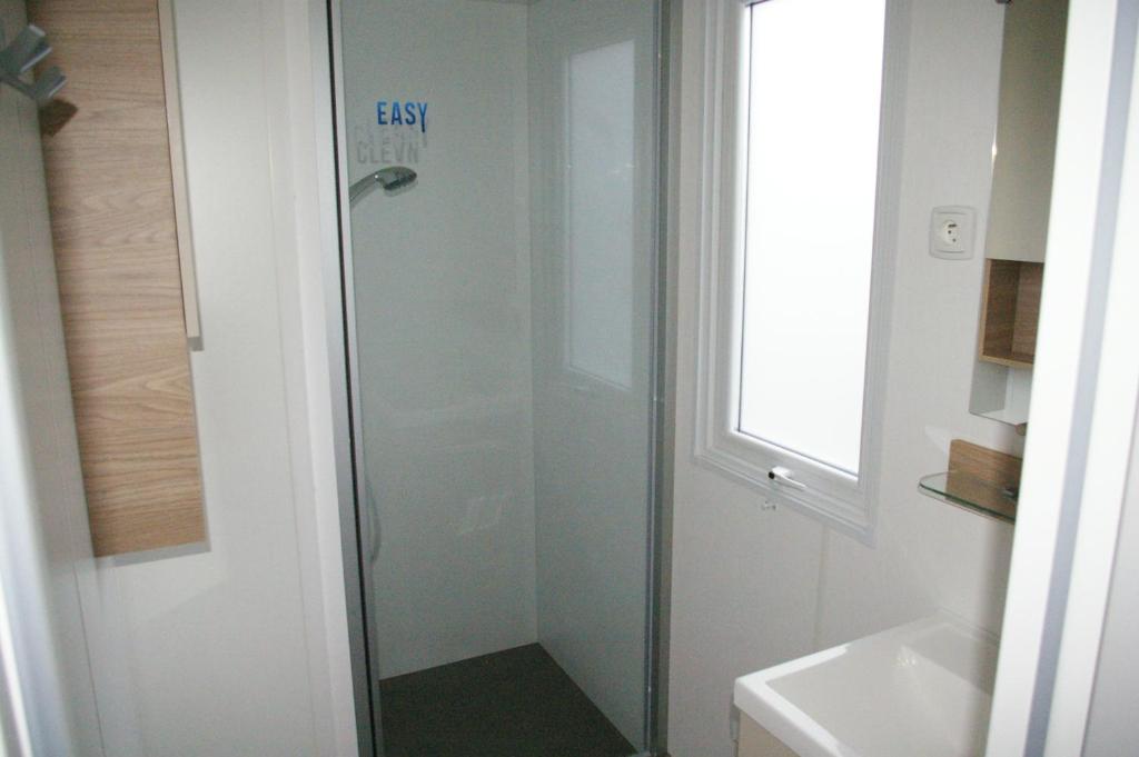 a shower in a bathroom with a glass door at mobil home 32 m² 4/6p in Onzain