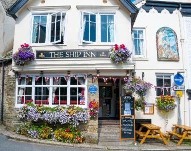 un bâtiment avec un panneau qui lit l'auberge dans l'établissement The Ship Inn Fowey, à Fowey