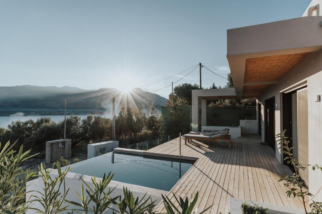 a house with a swimming pool on a balcony with the sun shining at Villa Panorama in Paleros