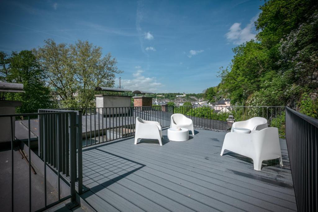 3 sedie bianche sedute su una terrazza di legno di APT. STONE-LODGE a Salisburgo