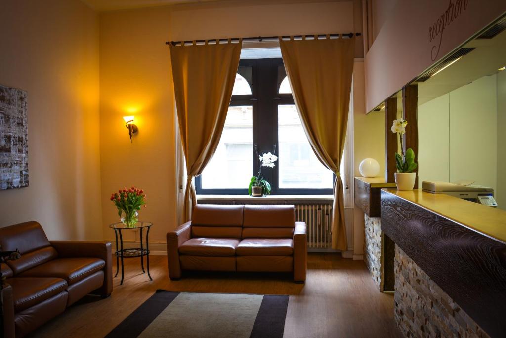 a living room with a couch and a chair at Hotel am Landeshaus in Wiesbaden