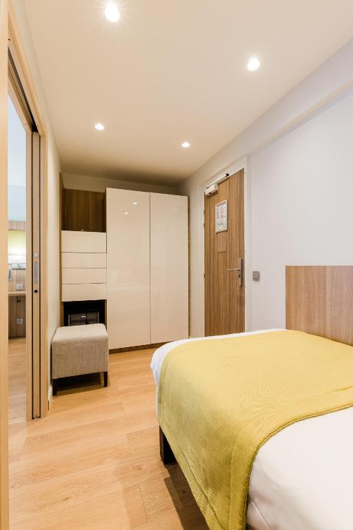 a hotel room with a bed and a chair at Hôtel Hélios in Juan-les-Pins