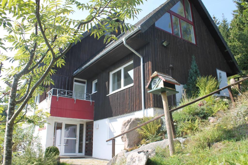 ein schwarzweißes Haus mit einer Uhr davor in der Unterkunft Berghaus Feldberg "Titiseeblick" in Bärental in Feldberg