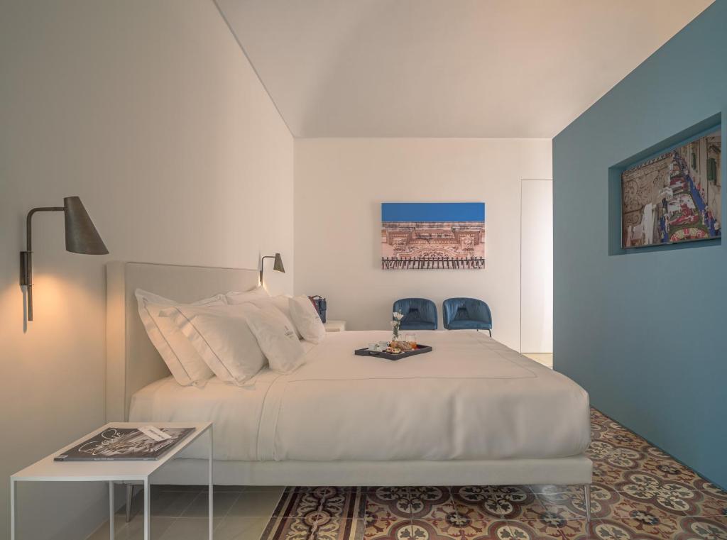 Un pat sau paturi într-o cameră la Sikelia Suites