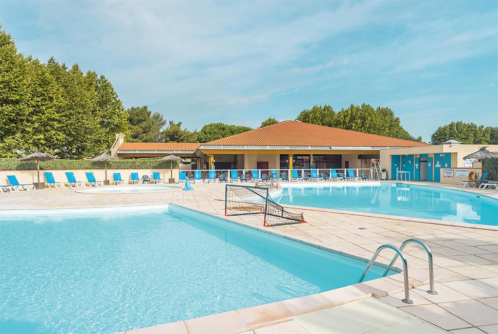 - une piscine d'eau bleue dans un complexe dans l'établissement Azureva Saint Cyprien, à Saint-Cyprien