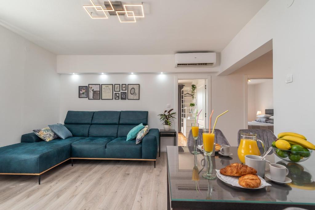 ein Wohnzimmer mit einem blauen Sofa und einem Tisch in der Unterkunft Luxury View Apartment Trogir in Trogir
